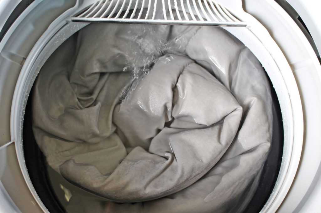 Стирать ватное одеяло можно в стиральной машине, но нельзя использовать режим отжима, потому что барабан может сломаться. Все же лучше стирать большие одеяла вручную.