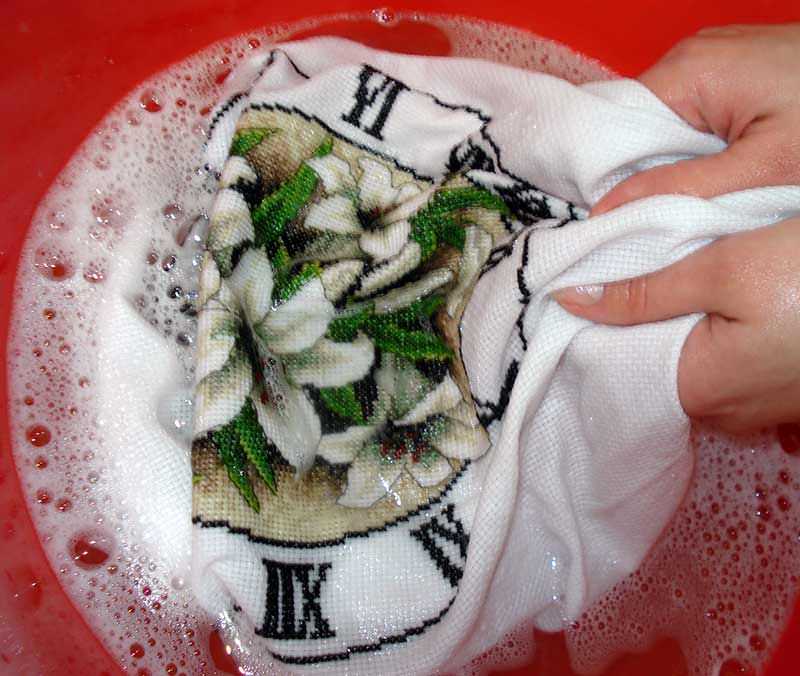 Чтобы вышивка не повредилась, стирать ее рекомендуют вручную, ни в коем случае не используя стиральную машину. Для начала замочите изделие в теплой воде на 5-10 минут.